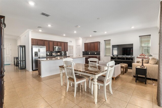 dining room featuring light tile patterned floors, visible vents, crown molding, and recessed lighting