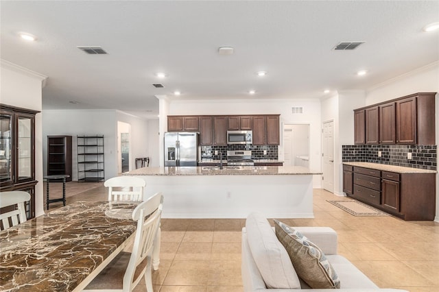 kitchen with a kitchen island with sink, visible vents, stainless steel appliances, and light tile patterned flooring