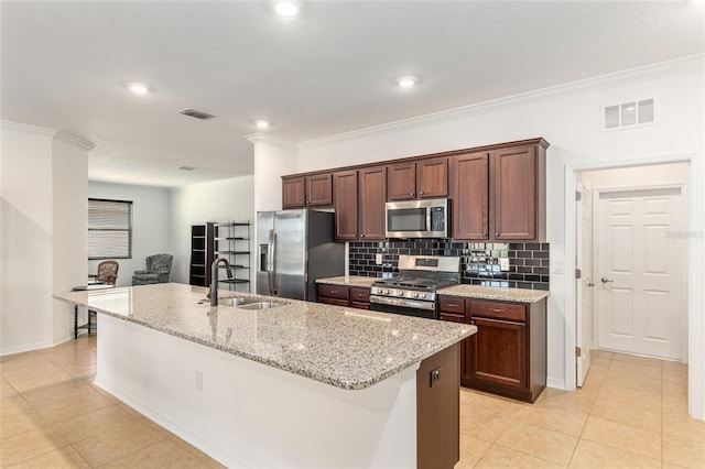 kitchen with appliances with stainless steel finishes, visible vents, a sink, and decorative backsplash