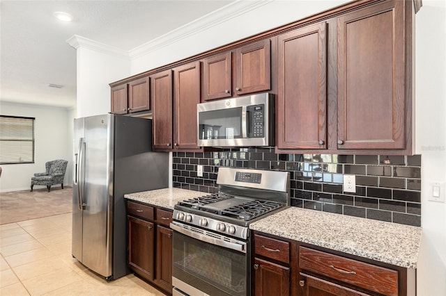 kitchen with light tile patterned flooring, stainless steel appliances, ornamental molding, backsplash, and light stone countertops