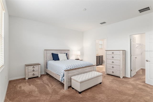 bedroom featuring a walk in closet, baseboards, visible vents, and carpet flooring