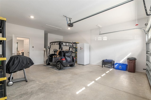 garage with concrete block wall and a garage door opener