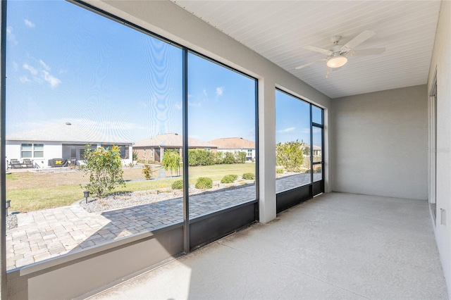 unfurnished sunroom featuring ceiling fan