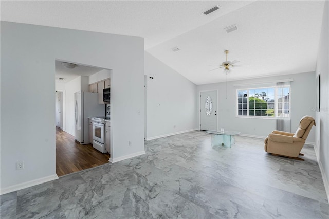 unfurnished living room with ceiling fan, visible vents, vaulted ceiling, and baseboards