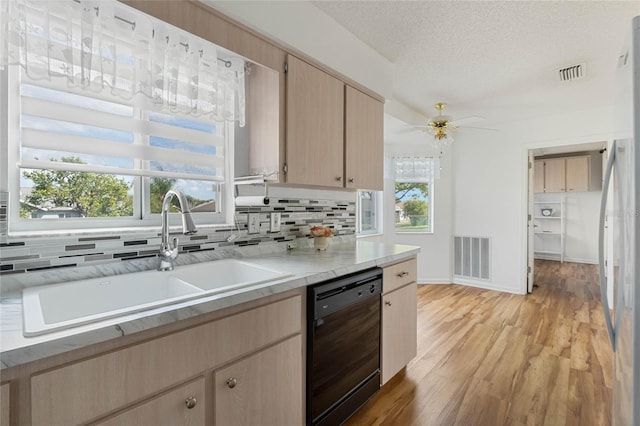 kitchen with black dishwasher, tasteful backsplash, light countertops, light brown cabinets, and a sink