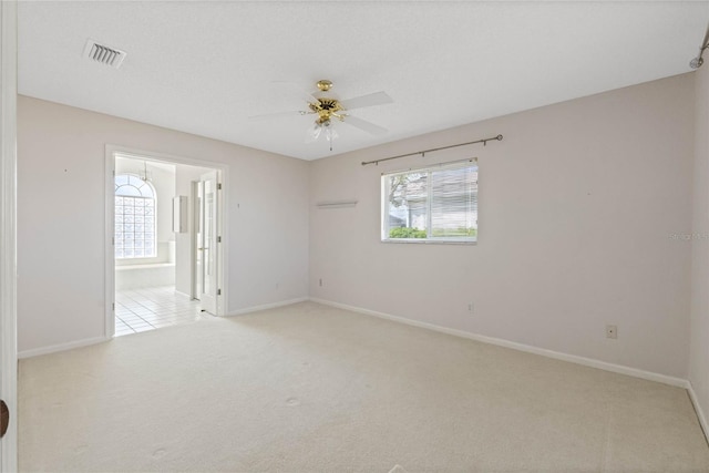 spare room featuring a ceiling fan, baseboards, visible vents, and carpet flooring