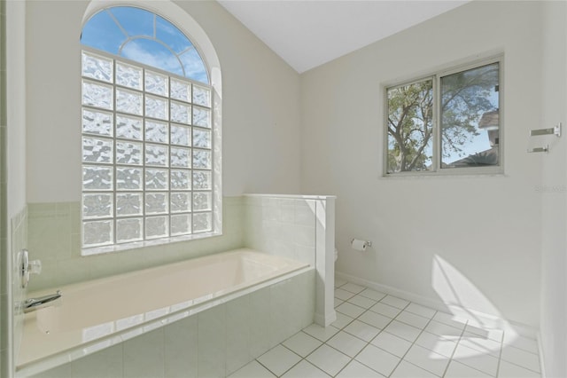 full bathroom with toilet, a garden tub, tile patterned flooring, and baseboards