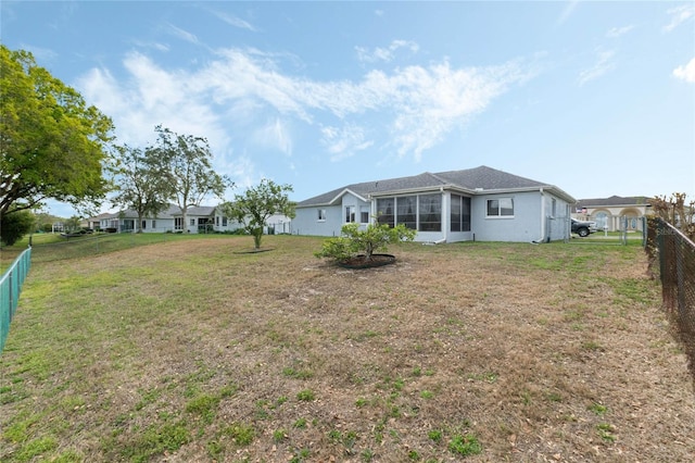 back of property with a sunroom, a fenced backyard, and a lawn