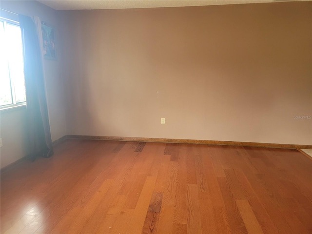 empty room featuring light wood-type flooring and baseboards