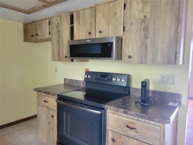 kitchen with black / electric stove, stainless steel microwave, dark countertops, and light brown cabinets