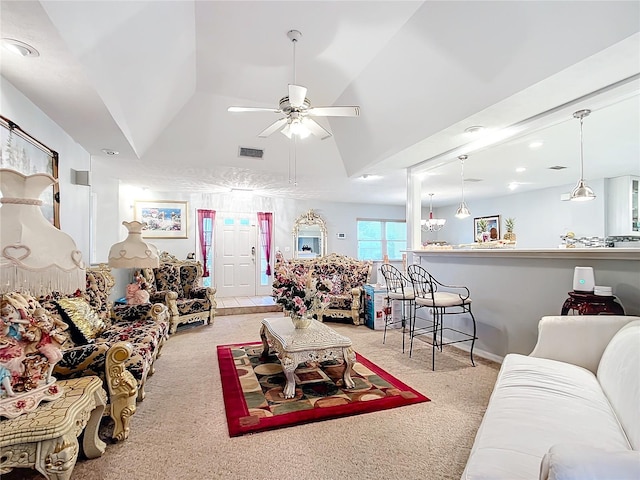 living area with visible vents, a ceiling fan, vaulted ceiling, and carpet flooring