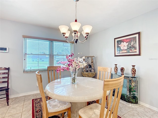 dining area featuring baseboards, light tile patterned flooring, and a notable chandelier