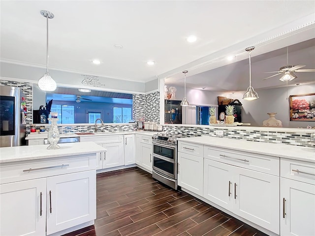 kitchen with stainless steel appliances, backsplash, white cabinets, and wood tiled floor