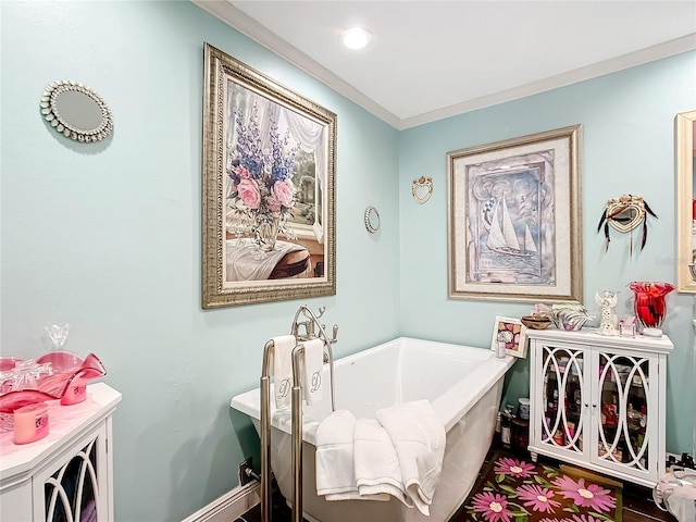 full bathroom with a freestanding tub, crown molding, and baseboards