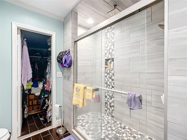 bathroom featuring a stall shower, wood tiled floor, and a spacious closet