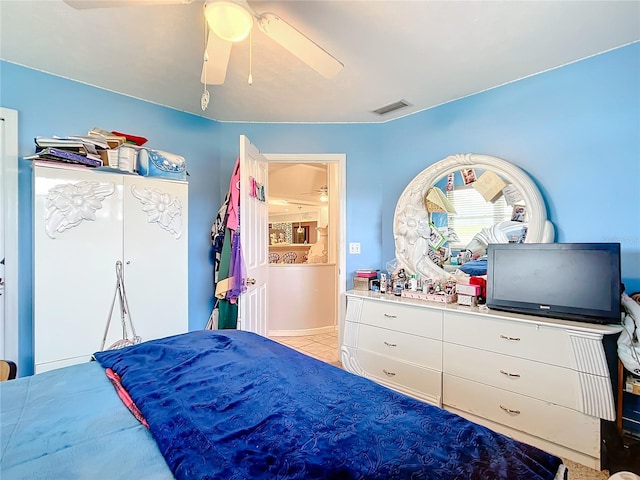 bedroom with ceiling fan, light tile patterned floors, and visible vents