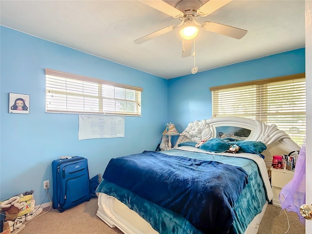 bedroom with a ceiling fan, multiple windows, and carpet flooring