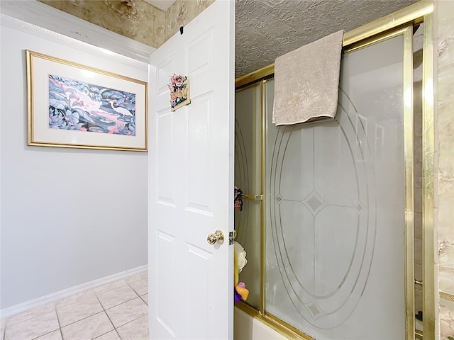 bathroom featuring a shower with shower door, baseboards, a textured ceiling, and tile patterned floors