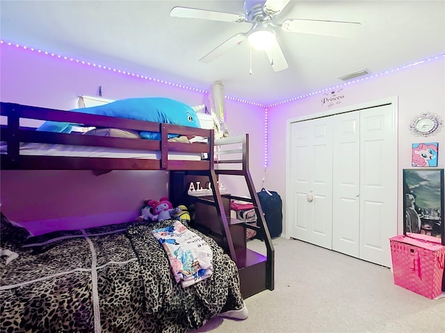 carpeted bedroom with a closet, visible vents, and ceiling fan