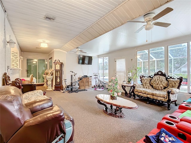 living area featuring carpet floors, visible vents, and ceiling fan