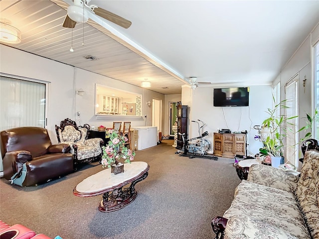 living area with visible vents, carpet, and a ceiling fan