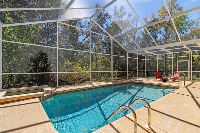 view of swimming pool featuring a patio, a lanai, and a pool with connected hot tub