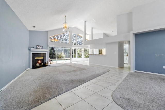 carpeted living area featuring a tiled fireplace, a textured ceiling, high vaulted ceiling, tile patterned flooring, and baseboards