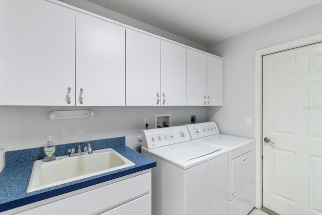 clothes washing area featuring washing machine and clothes dryer, a sink, and cabinet space