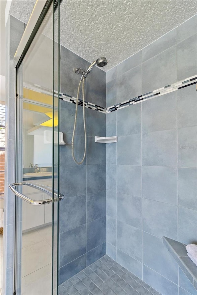 full bath with a stall shower and a textured ceiling