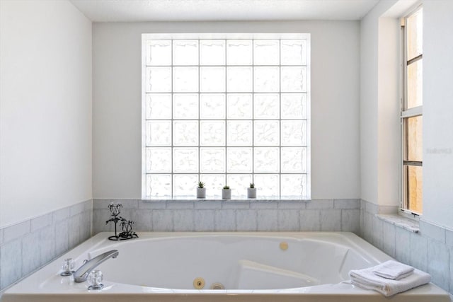 full bath featuring a jetted tub and plenty of natural light