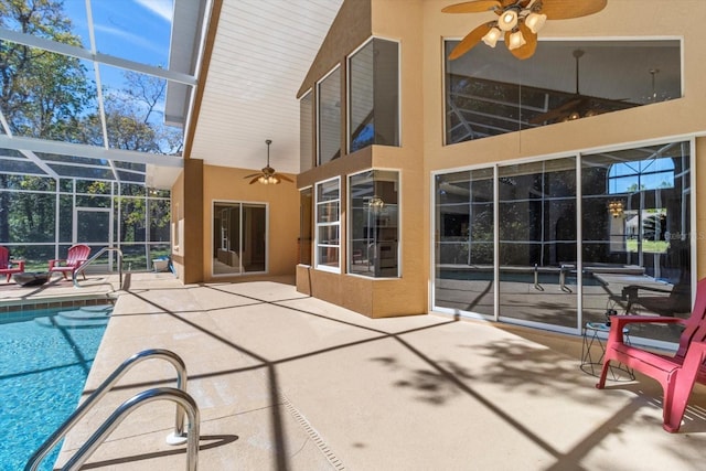 view of patio featuring glass enclosure, ceiling fan, and an outdoor pool