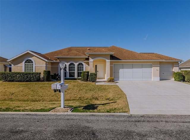 mediterranean / spanish house with an attached garage, a shingled roof, a front lawn, stucco siding, and driveway