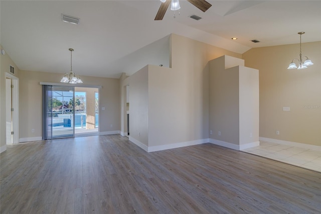 spare room featuring visible vents, wood finished floors, and vaulted ceiling