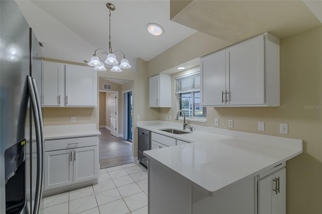 kitchen with visible vents, a sink, stainless steel appliances, a peninsula, and light countertops