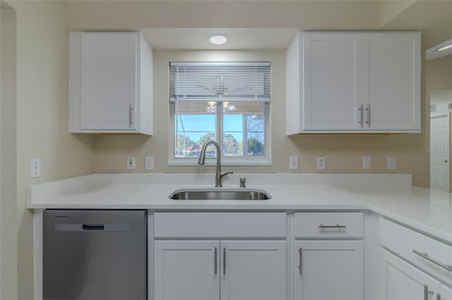 kitchen with dishwasher, light countertops, white cabinets, and a sink