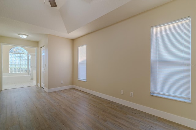 spare room featuring wood finished floors, baseboards, and ceiling fan