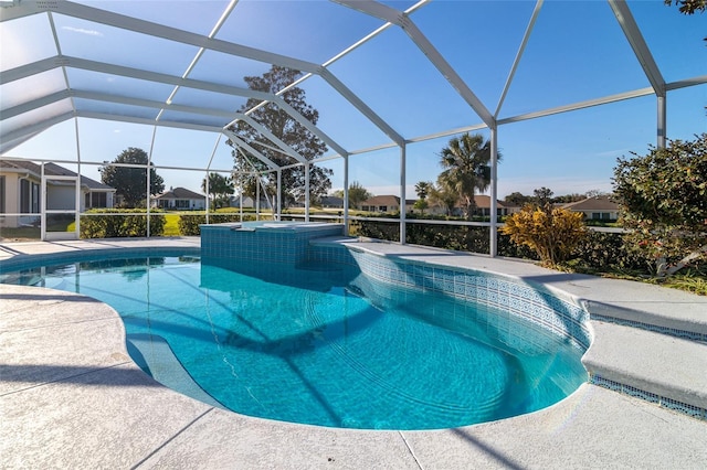 view of pool with glass enclosure, a patio area, and a pool with connected hot tub