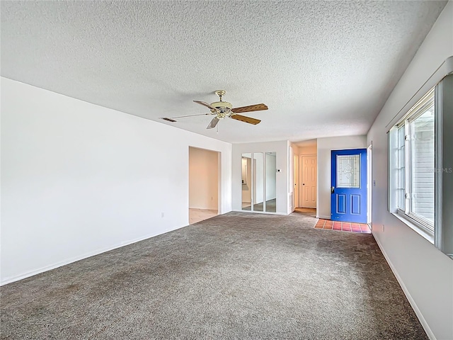 unfurnished room with a ceiling fan, carpet flooring, and a textured ceiling