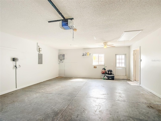 garage featuring a garage door opener, electric panel, and baseboards