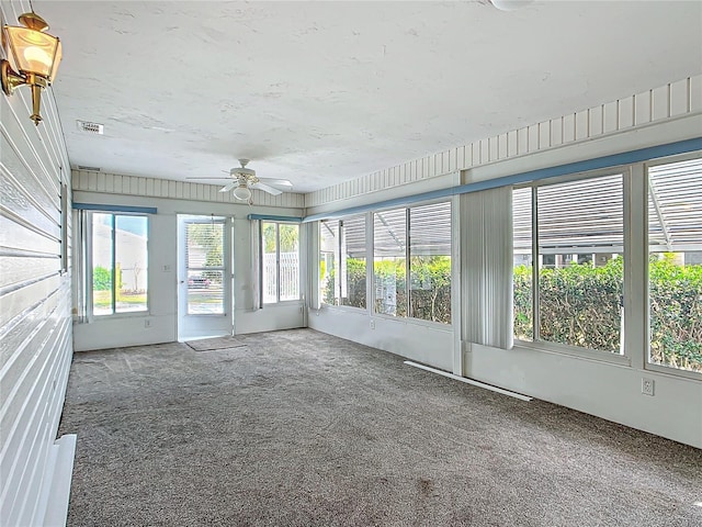 unfurnished sunroom featuring visible vents and a ceiling fan