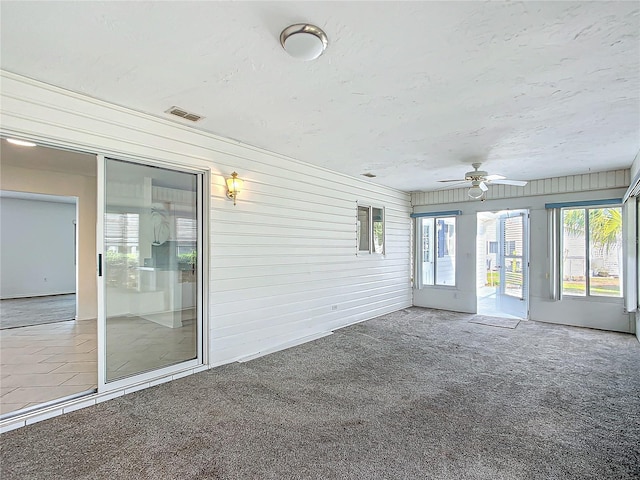 unfurnished sunroom featuring a ceiling fan