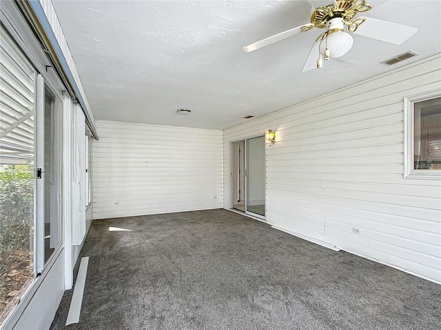 unfurnished sunroom with visible vents and a ceiling fan