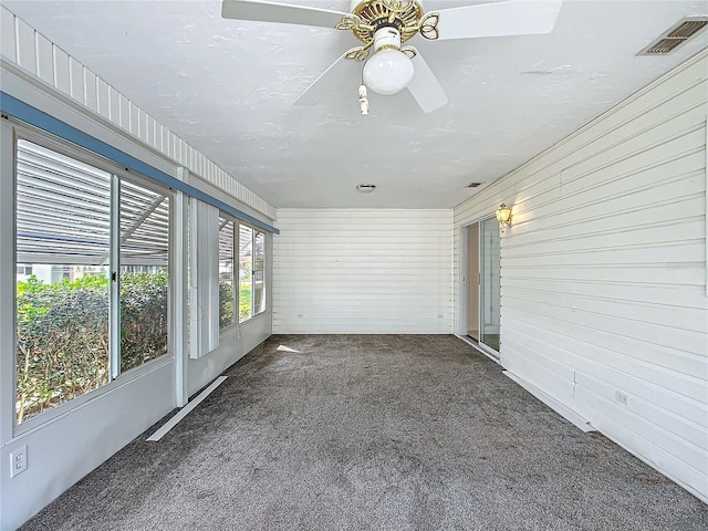 unfurnished sunroom with visible vents and a ceiling fan