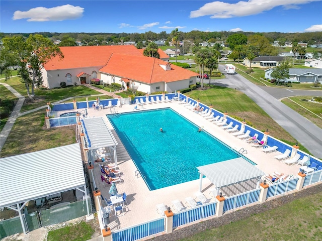 community pool with fence and a patio