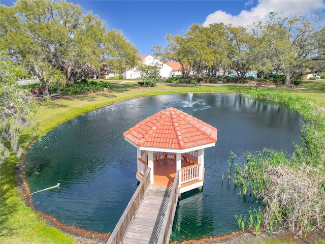 view of dock with a water view and a lawn