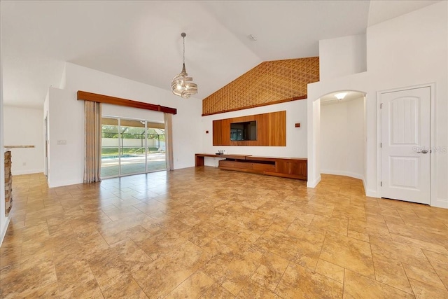 6307 SE 8th Ln, Ocala, FL 34472 - unfurnished living room with high vaulted ceiling, arched walkways, baseboards, and light stone finish flooring