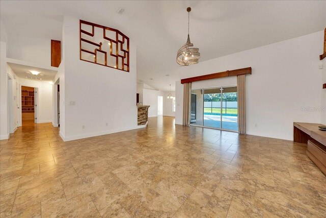 6307 SE 8th Ln, Ocala, FL 34472 - unfurnished living room with stone finish floors, high vaulted ceiling, and baseboards