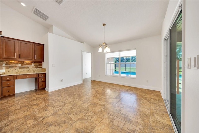 6307 SE 8th Ln, Ocala, FL 34472 - unfurnished dining area featuring a chandelier, vaulted ceiling, stone tile flooring, and baseboards