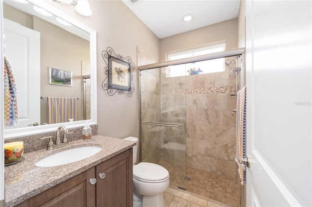 full bath with toilet, a stall shower, vanity, and tile patterned flooring