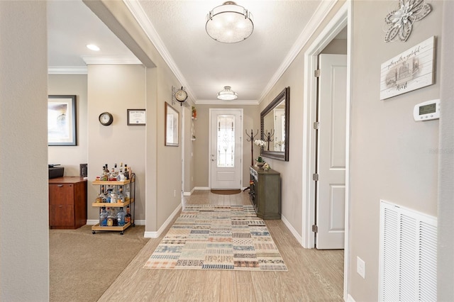 entryway featuring crown molding, baseboards, and visible vents